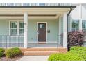 Inviting front porch with brick steps and a stylish wood front door at 905 E Lenoir St, Raleigh, NC 27610