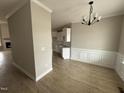 Open-concept dining room with modern chandelier and an opening to the kitchen and an adjacent living room space at 94 Royal Ave, Selma, NC 27576