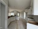 Open-concept kitchen with white cabinets, trim work, and a view of the living room and fireplace at 94 Royal Ave, Selma, NC 27576