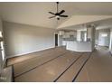 Open-concept living room showcasing vaulted ceilings, ceiling fan, and seamless transition to the kitchen at 94 Royal Ave, Selma, NC 27576