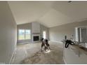 Living room with a vaulted ceiling, white fireplace, large windows, and lots of natural light at 94 Royal Ave, Selma, NC 27576