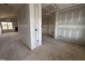 An expansive living room is shown with unfinished drywall and large window at 94 Royal Ave, Selma, NC 27576
