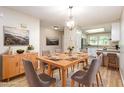 Elegant dining room with a wooden table, seating for six, modern lighting, and seamless flow to the kitchen at 1015 Boathouse Ct, Raleigh, NC 27615