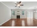 Spacious living room featuring a fireplace, ceiling fan, hardwood floors and light gray walls at 10504 Carsons Creek Dr, Zebulon, NC 27597
