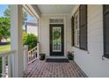 Inviting front porch with a decorative wreath, black door, and potted plants at 10608 Thornbury Crest Ct Ct, Raleigh, NC 27614