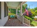 Charming front porch with brick floor, bench with pillows, and an American flag at 10608 Thornbury Crest Ct Ct, Raleigh, NC 27614