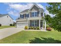 Well-maintained home with a lush green lawn, gray siding, and a charming front porch, perfect for relaxation at 107 Southern Acres Dr, Fuquay Varina, NC 27526