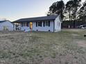 Single-story home featuring a well-maintained lawn and a carport on the side at 109 Pine St, Dunn, NC 28334