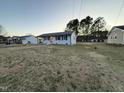 Spacious front yard with a one-story home, surrounded by mature trees at 109 Pine St, Dunn, NC 28334