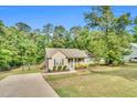 Inviting single-story home showcases a well-maintained lawn, long driveway, and peaceful, wooded surroundings at 114 Cherryhill Dr, Four Oaks, NC 27524