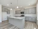View of kitchen with gray cabinets, white countertops, stainless appliances, and a center island at 1248 Randwick Valley Ct, Zebulon, NC 27597