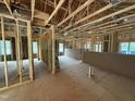 Open-concept living room features framing, insulation, and natural light from windows during construction phase at 13159 S Nc-231 Hwy, Middlesex, NC 27557