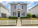 Two-story home with gray siding, black shutters, and a well-manicured front yard with picket fence at 141 Shad Boat Ln, Clayton, NC 27520