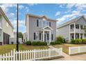 Two-story home with tidy landscaping and charming white picket fence on a sunny day with blue sky at 141 Shad Boat Ln, Clayton, NC 27520