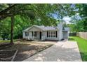 Inviting home with a cozy front porch, gray siding, black shutters, and a well-maintained front yard at 144 Holly Mountain Rd, Holly Springs, NC 27540