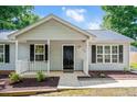 Attractive home exterior showcases a welcoming front porch and classic design elements, framed by tidy landscaping at 144 Holly Mountain Rd, Holly Springs, NC 27540