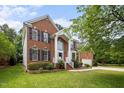 Attractive brick home with a two-story entrance, well-maintained lawn, and mature landscaping at 15 Aman Ct, Durham, NC 27713