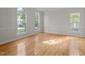 Bright living room with hardwood floors, chair rail, and large windows offering ample natural light at 15 Aman Ct, Durham, NC 27713