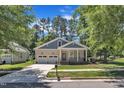Beautiful front exterior of a home with a cozy porch, lush lawn, and convenient two-car garage at 151 Cobble Ridge Dr, Pittsboro, NC 27312