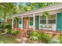 Inviting front porch with colorful shutters, brick steps, and decorative bench at 1703 Keogh St, Burlington, NC 27215