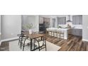 Bright open kitchen features an island with seating and stainless appliances adjacent to the dining area at 1740 Golden Honey Dr, Wake Forest, NC 27587