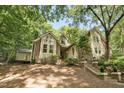 Stylish home on a sloped lot with mature trees, brick accents and neutral siding at 201 Red Bud Ln, Chapel Hill, NC 27514