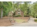Attractive brick and siding home with mature trees, landscaping, and winding driveway at 201 Red Bud Ln, Chapel Hill, NC 27514