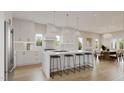 Spacious, modern kitchen with white cabinets, marble countertops, and seating for six at 203 E Winmore Ave, Chapel Hill, NC 27516