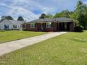Brick home with a long driveway and manicured lawn at 213 N Brevard St, Selma, NC 27576