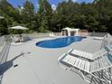 Relaxing backyard pool with a waterfall feature, comfortable lounge chairs, and an umbrella-covered seating area at 2483 Mcneill Hobbs Rd, Bunnlevel, NC 28323
