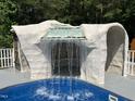 Amazing detail of a stone-like grotto with a built-in waterfall cascading into the sparkling swimming pool at 2483 Mcneill Hobbs Rd, Bunnlevel, NC 28323