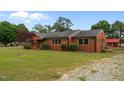 Spacious property featuring a well-maintained brick home with a lush green lawn at 305 W Old Rd, Lillington, NC 27546