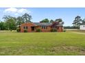 Quaint brick ranch with mature landscaping and expansive front lawn at 305 W Old Rd, Lillington, NC 27546