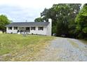 Side view of a lovely one-story brick home with black shutters, clean lines, and a gravel driveway at 3141 Wagoner Ln # 09, Graham, NC 27253
