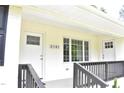 Close up of the front porch with white brick, dark wood railing, and views of the house numbers at 3141 Wagoner Ln # 09, Graham, NC 27253