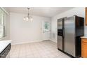 Open Kitchen that includes stainless steel refrigerator, tile flooring, and an adjacent dining area at 3713 Phillips W Way, Durham, NC 27713