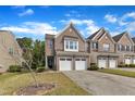 Well-maintained townhomes with brick facades, double garages, and established landscaping at 416 Durants Neck Ln, Morrisville, NC 27560