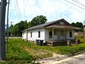 A humble single story residence with a covered porch and mature green space surrounds it at 422 Nance St, Rocky Mount, NC 27803