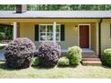 The front exterior of a home with a brick entryway, shutters, and landscaping at 4221 River Run Dr, Sanford, NC 27332