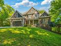 Charming home with a beautifully landscaped front yard, attached garage, and stone and wood facade at 445 Ridge Springs Dr, Chapel Hill, NC 27516