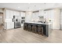 Bright kitchen with white cabinets, stainless steel appliances, and a large island with seating at 488 Freedom Trail Dr, Angier, NC 27592
