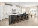 Stylish kitchen with white cabinets, stainless steel appliances, island seating, and an adjacent dining area at 488 Freedom Trail Dr, Angier, NC 27592