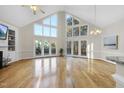Bright, open living room with vaulted ceilings, hardwood floors, and large windows at 50 Tyler Ct, Henderson, NC 27537