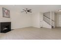 Open living room with a fireplace, a ceiling fan, and staircase to the upper level at 509 Darby Glen Ln, Durham, NC 27713