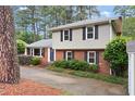Charming two-story home with brick and grey siding, black shutters, and mature trees at 509 E Millbrook Rd, Raleigh, NC 27609
