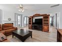 Spacious living room with hardwood floors, a ceiling fan, and a large media center at 5416 Whisperwood Dr, Durham, NC 27713