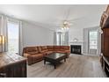 Bright living room featuring a fireplace, hardwood floors, and large windows at 5416 Whisperwood Dr, Durham, NC 27713