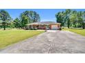 Quaint brick ranch-style home featuring a lush lawn, ample parking, and an attached garage at 585 Cokesbury Rd, Fuquay Varina, NC 27526