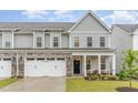 Exterior of a two-story townhome featuring a stone-accented garage and inviting front porch at 646 Shelford Trl, Zebulon, NC 27597