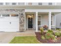 Inviting front entrance with a black door, decorative wreath, and cozy porch seating area at 646 Shelford Trl, Zebulon, NC 27597
